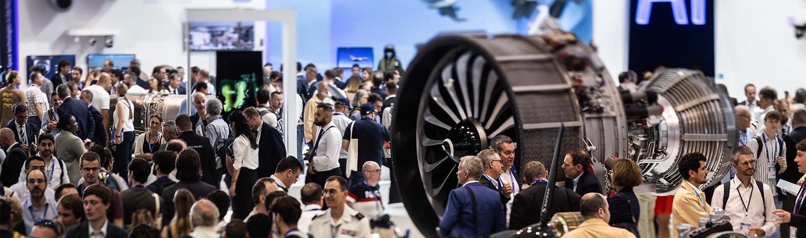 Professional visitors gathered around an aircraft engine displayed at a stand during the Paris Air Show in Paris-Le Bourget.