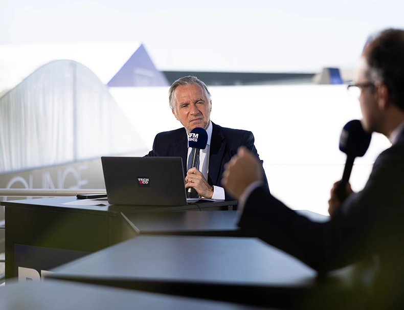 Journalist conducting an interview on a media set during the Paris Air Show in Paris-Le Bourget.