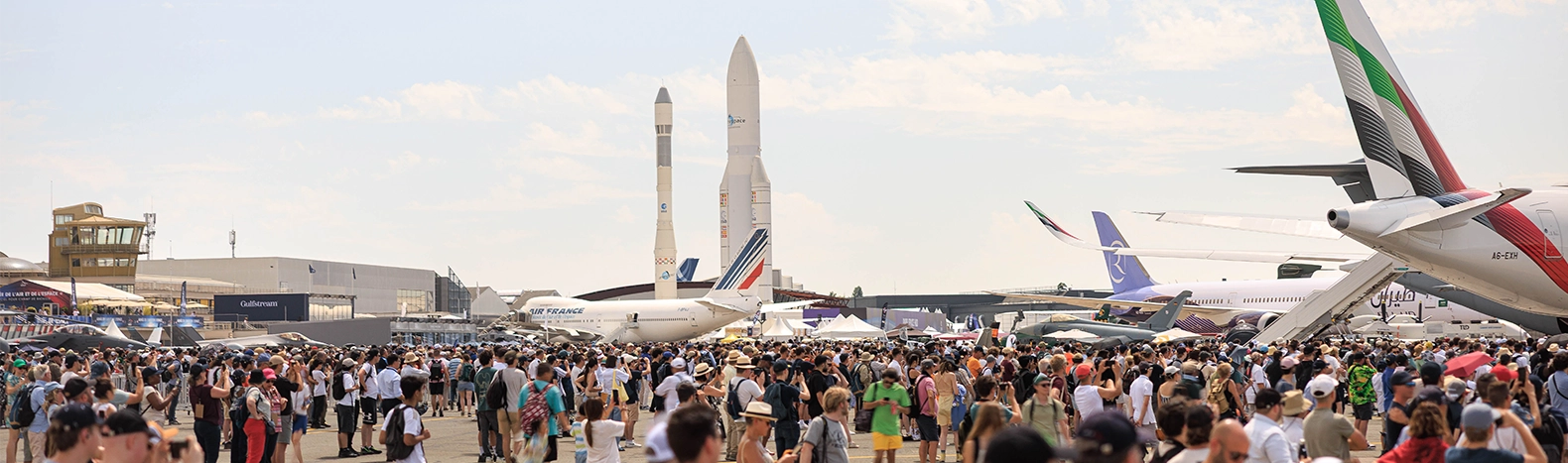 Visiteurs découvrant les aéronefs et les fusées Ariane exposés au Salon International de l’Aéronautique et de l’Espace à Paris-Le Bourget.