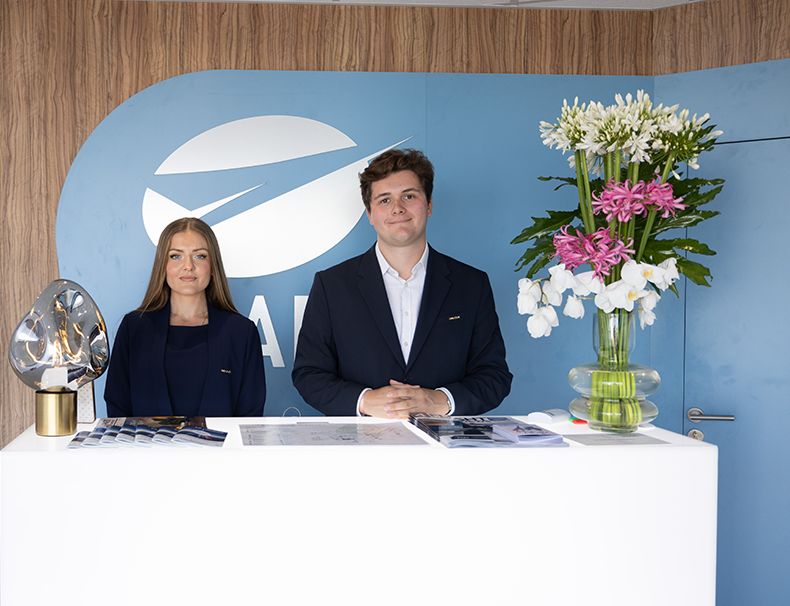 Service d’accueil sur un stand aménagé avec une composition florale au Paris Air Show.